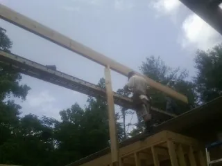 Carpenter setting a ridge beam over a new addition frame — Ice Dam Removal by Roofing Brothers in Apollo Beach